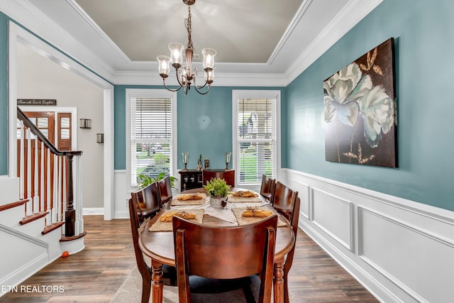 dining space featuring a healthy amount of sunlight, an inviting chandelier, ornamental molding, and stairs