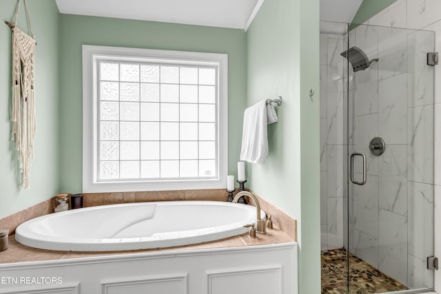 bathroom featuring a garden tub, a marble finish shower, and a healthy amount of sunlight