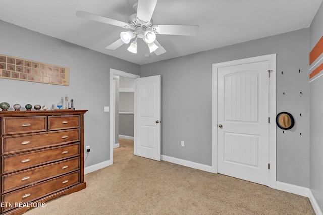 bedroom featuring light colored carpet, baseboards, and a ceiling fan