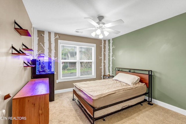 carpeted bedroom featuring baseboards, a ceiling fan, and visible vents
