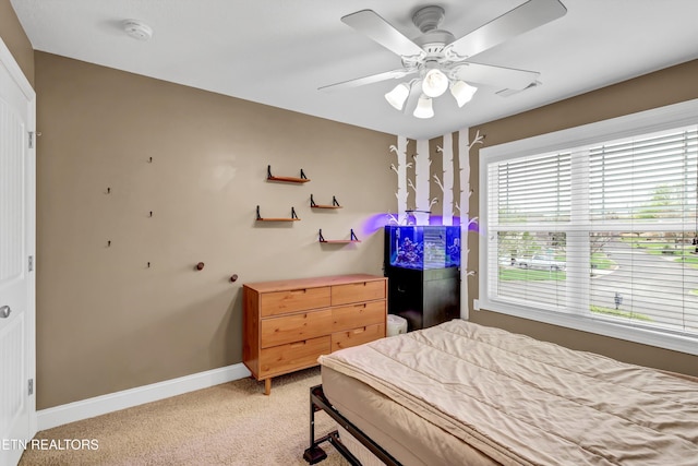 bedroom featuring light carpet, visible vents, baseboards, and a ceiling fan
