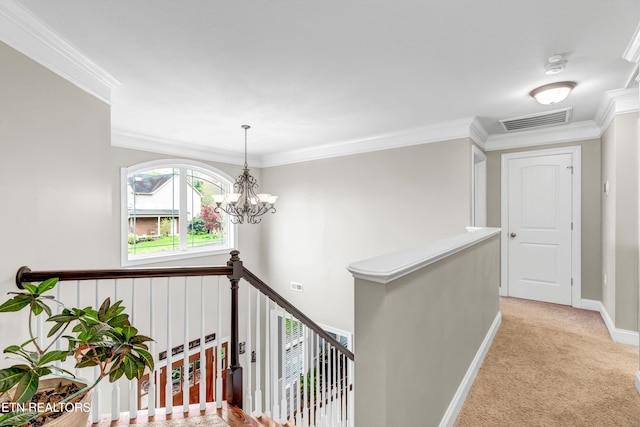 hall with a notable chandelier, an upstairs landing, crown molding, visible vents, and light colored carpet