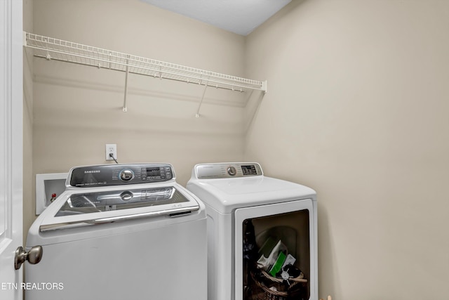 washroom with independent washer and dryer and laundry area