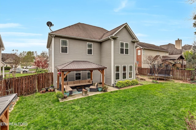 rear view of house with an outdoor living space, a fenced backyard, a patio area, a gazebo, and a trampoline