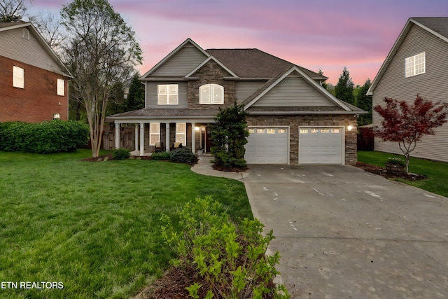 view of front of property with driveway, stone siding, an attached garage, a porch, and a lawn