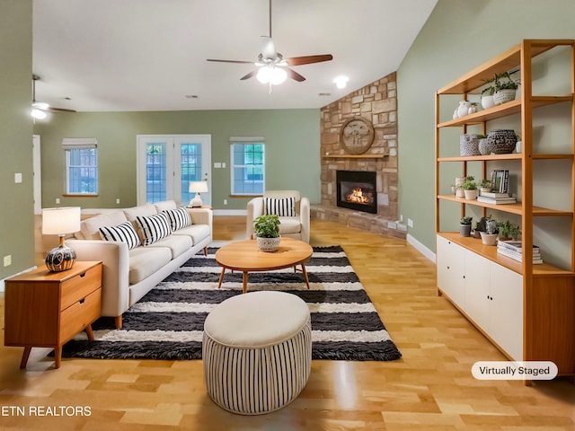 1056 Willow Creek Cir, Maryville, TN 37804 - living room with baseboards, a stone fireplace, vaulted ceiling, light wood-style floors, and ceiling fan