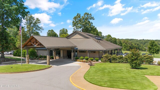102 Chaloni Ln, Loudon, TN 37774 - view of front of house featuring aphalt driveway, metal roof, stone siding, and a front lawn
