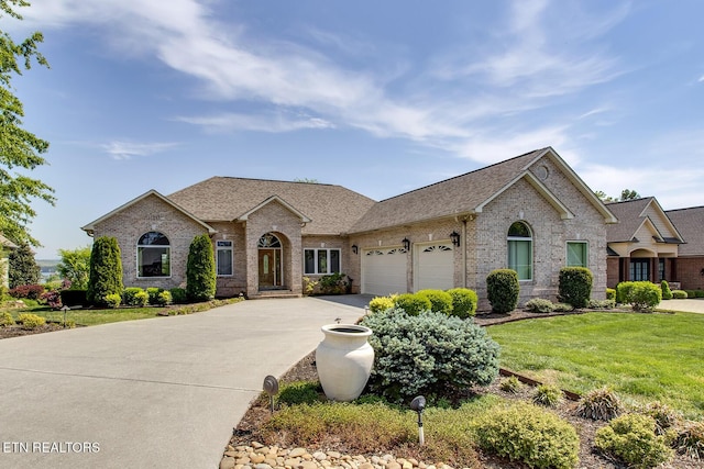 304 Coweta Ct, Loudon, TN 37774 - french country home featuring a front lawn, a garage, a shingled roof, brick siding, and concrete driveway
