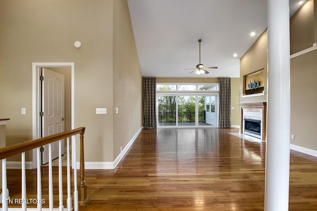 304 Coweta Ct, Loudon, TN 37774 - unfurnished living room featuring baseboards, a tile fireplace, wood finished floors, a ceiling fan, and high vaulted ceiling