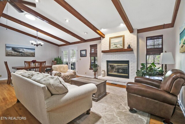13 Oxford Cir, Fairfield Glade, TN 38558 - living room featuring light wood-style floors, baseboards, vaulted ceiling with beams, and a brick fireplace