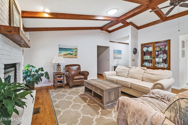 13 Oxford Cir, Fairfield Glade, TN 38558 - living room with visible vents, a ceiling fan, a fireplace, wood finished floors, and vaulted ceiling with beams