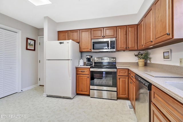13 Oxford Cir, Fairfield Glade, TN 38558 - kitchen with brown cabinetry, light countertops, and stainless steel appliances