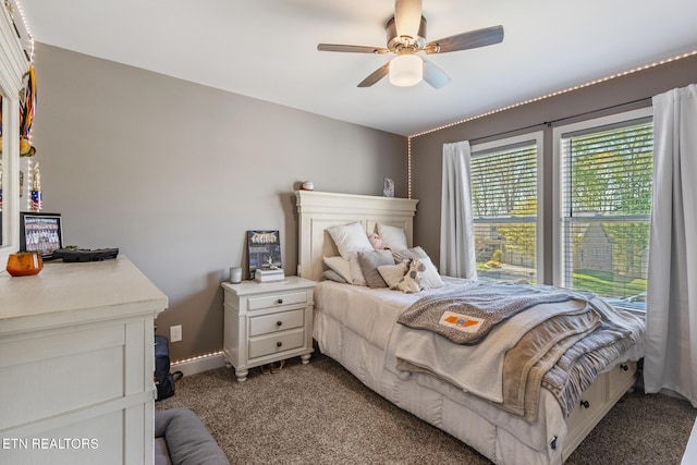 bedroom with ceiling fan, dark colored carpet, and baseboards
