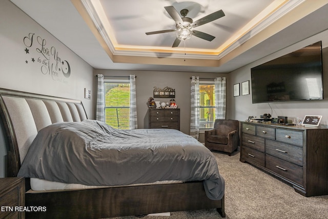 bedroom featuring ceiling fan, a raised ceiling, and light colored carpet