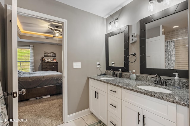 bathroom featuring double vanity, a sink, a ceiling fan, and baseboards