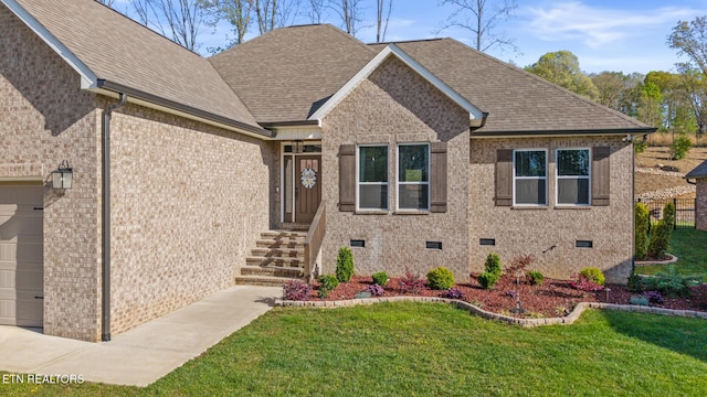 view of front of house with a front yard, an attached garage, crawl space, and roof with shingles
