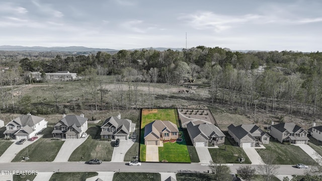 drone / aerial view with a view of trees, a mountain view, and a residential view