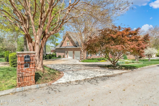 view of property hidden behind natural elements featuring a front lawn and driveway