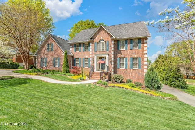 view of front facade featuring a front yard and brick siding