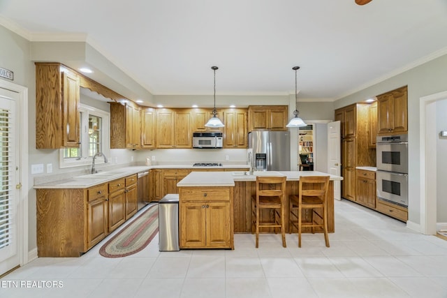 kitchen featuring light countertops, a center island, appliances with stainless steel finishes, and a sink