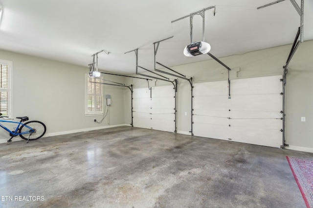 garage with baseboards and a garage door opener
