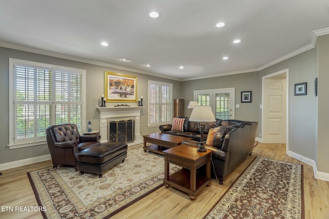 living area with light wood-style flooring, crown molding, baseboards, and a wealth of natural light