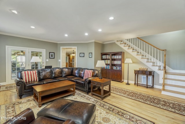 living area featuring stairs, baseboards, crown molding, and wood finished floors