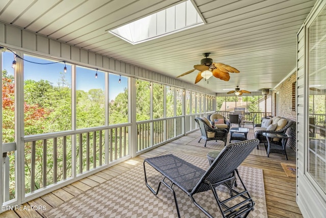 sunroom featuring an outdoor living space, ceiling fan, and a skylight