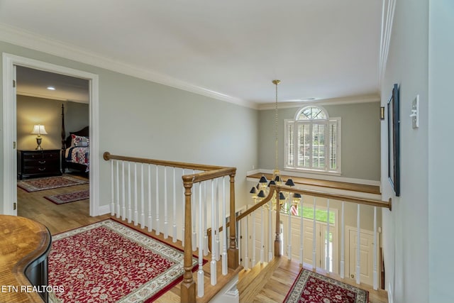 stairway featuring baseboards, crown molding, and wood finished floors