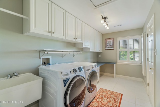 clothes washing area with attic access, a sink, washer and dryer, baseboards, and cabinet space