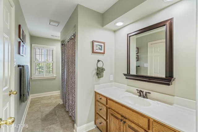 full bathroom featuring baseboards and vanity