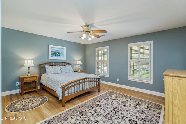 bedroom with wood finished floors, ceiling fan, and baseboards