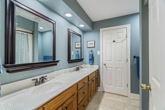 bathroom with recessed lighting, double vanity, visible vents, and a sink