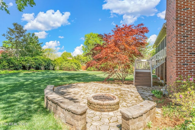 view of yard featuring a wooden deck, a fire pit, a patio, and stairs