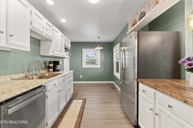 2214 Lincoln St, Knoxville, TN 37920 - kitchen featuring baseboards, light wood-type flooring, white cabinetry, stainless steel appliances, and a sink