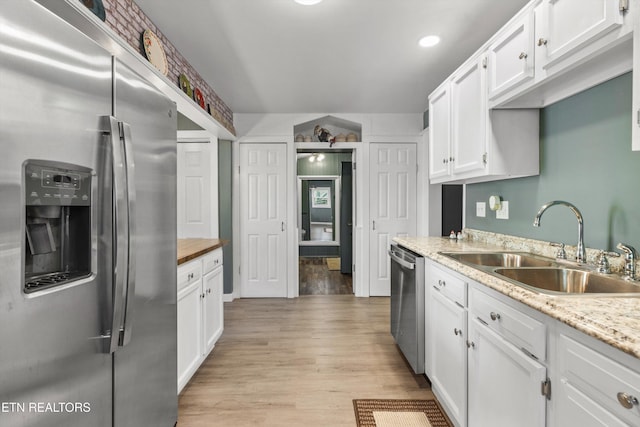 2214 Lincoln St, Knoxville, TN 37920 - kitchen with white cabinets, a sink, appliances with stainless steel finishes, light wood-style floors, and recessed lighting