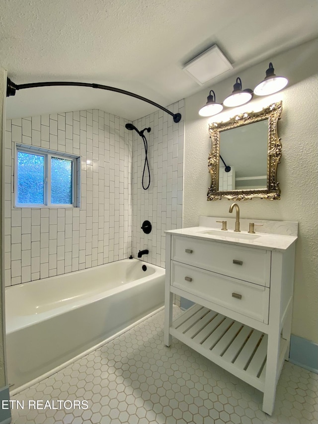full bath featuring tile patterned floors, shower / bath combination, vanity, and a textured ceiling