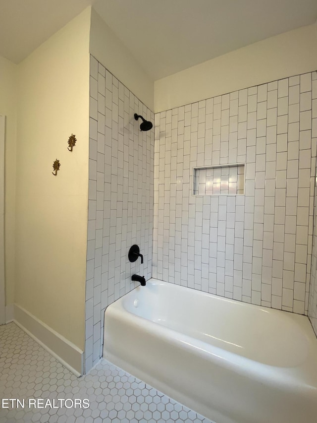 bathroom with baseboards, tile patterned flooring, and bathing tub / shower combination