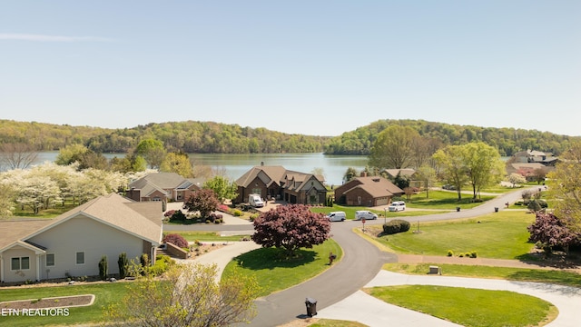 birds eye view of property featuring a water view, a view of trees, and a residential view