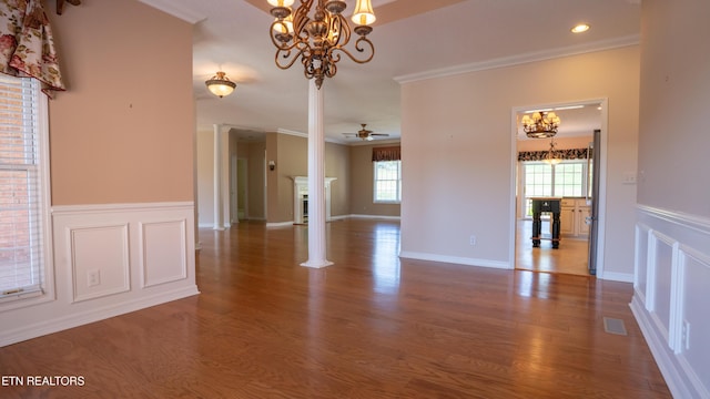 interior space featuring a decorative wall, crown molding, a wainscoted wall, and wood finished floors