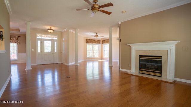 unfurnished living room with ornate columns, ceiling fan, and ornamental molding