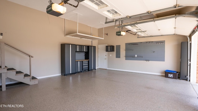 garage with electric panel, baseboards, and a garage door opener