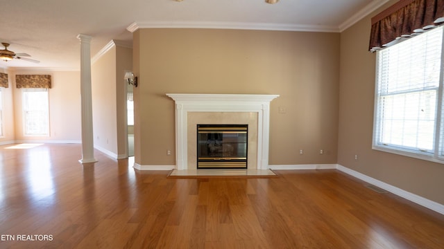 unfurnished living room featuring baseboards, crown molding, and wood finished floors