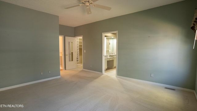 spare room with light carpet, ceiling fan, baseboards, and visible vents