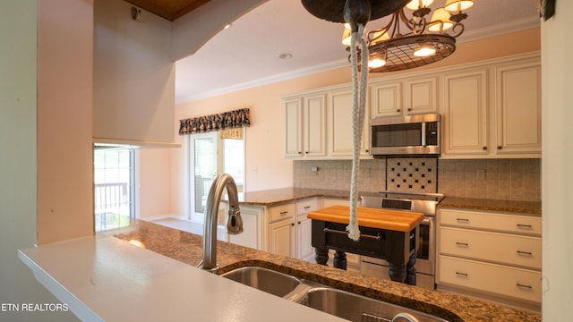 kitchen with stainless steel appliances, a peninsula, crown molding, and decorative backsplash