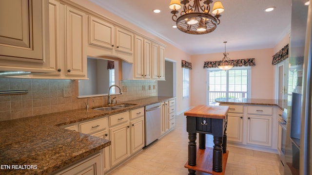 kitchen featuring tasteful backsplash, dishwasher, a sink, a chandelier, and cream cabinets