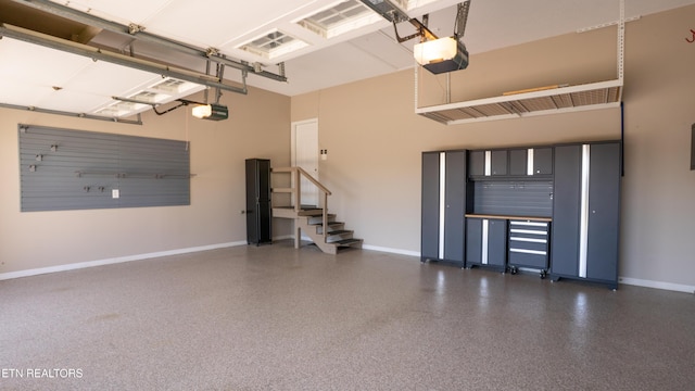 garage with baseboards and a garage door opener
