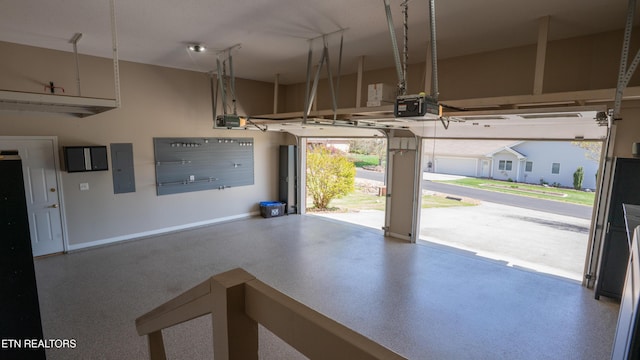 garage with a garage door opener, baseboards, and electric panel