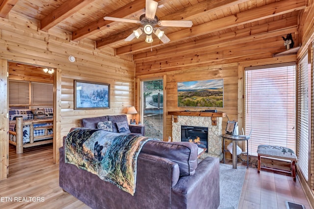 906 Black Bear Cub Way, Sevierville, TN 37862 - bedroom with light wood-style floors, wooden ceiling, beam ceiling, wooden walls, and a stone fireplace