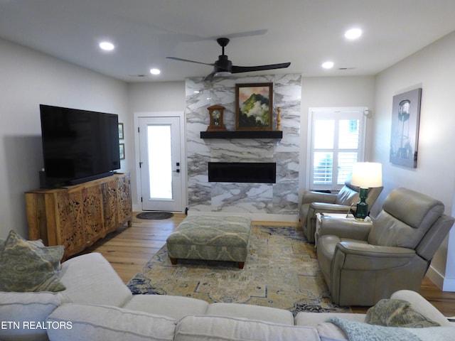 living area featuring wood finished floors, a fireplace, a ceiling fan, and recessed lighting